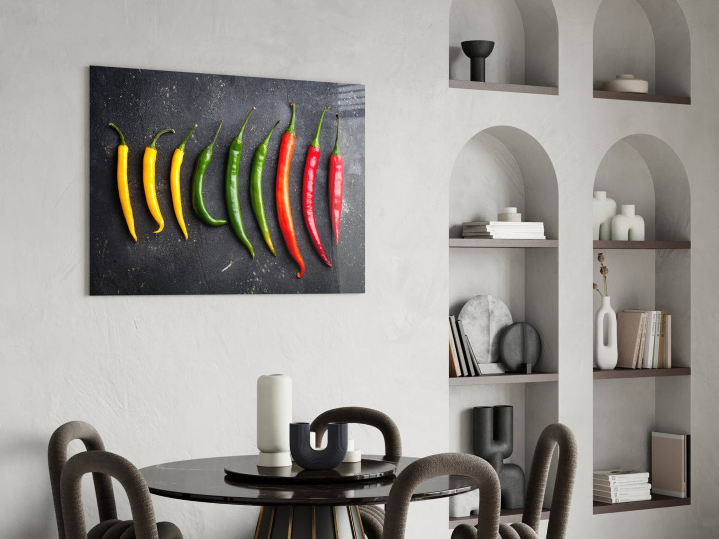 Glass wall art depicting ten chili peppers in yellow, green, and red arranged horizontally on dark gray background, displayed above dining table.