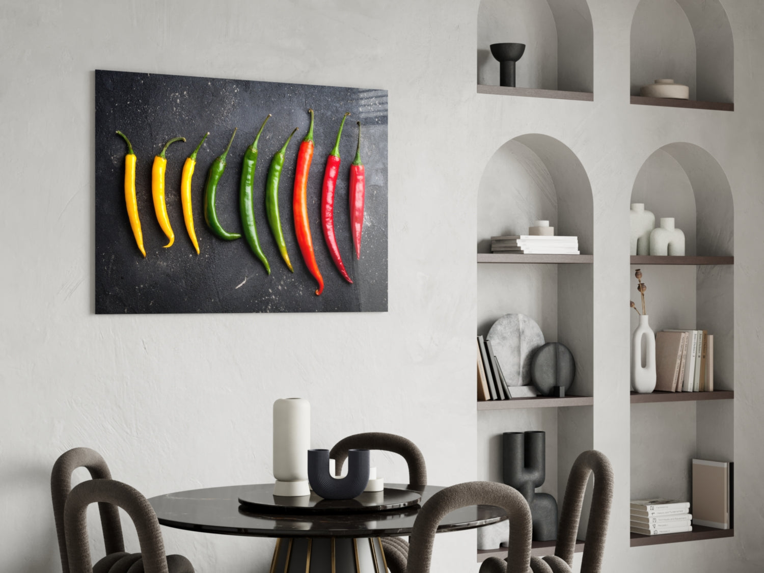 Glass wall art depicting ten chili peppers in yellow, green, and red arranged horizontally on dark gray background, displayed above dining table.