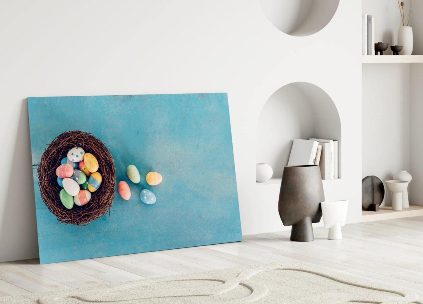 Turquoise canvas art leaning against white wall displays nest with colorful Easter eggs spilling out, styled with modern home décor.