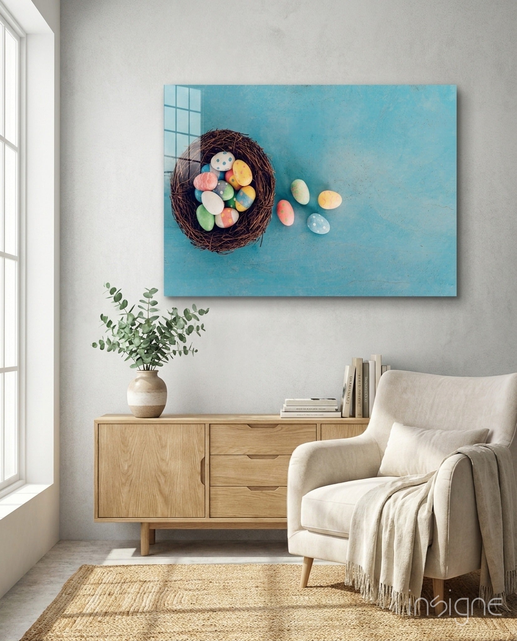 Easter egg glass wall art with turquoise background displayed above wooden dresser in modern living room setting.