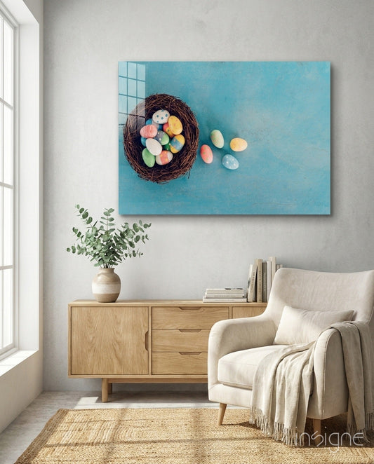 Easter egg glass wall art with turquoise background displayed above wooden dresser in modern living room setting.