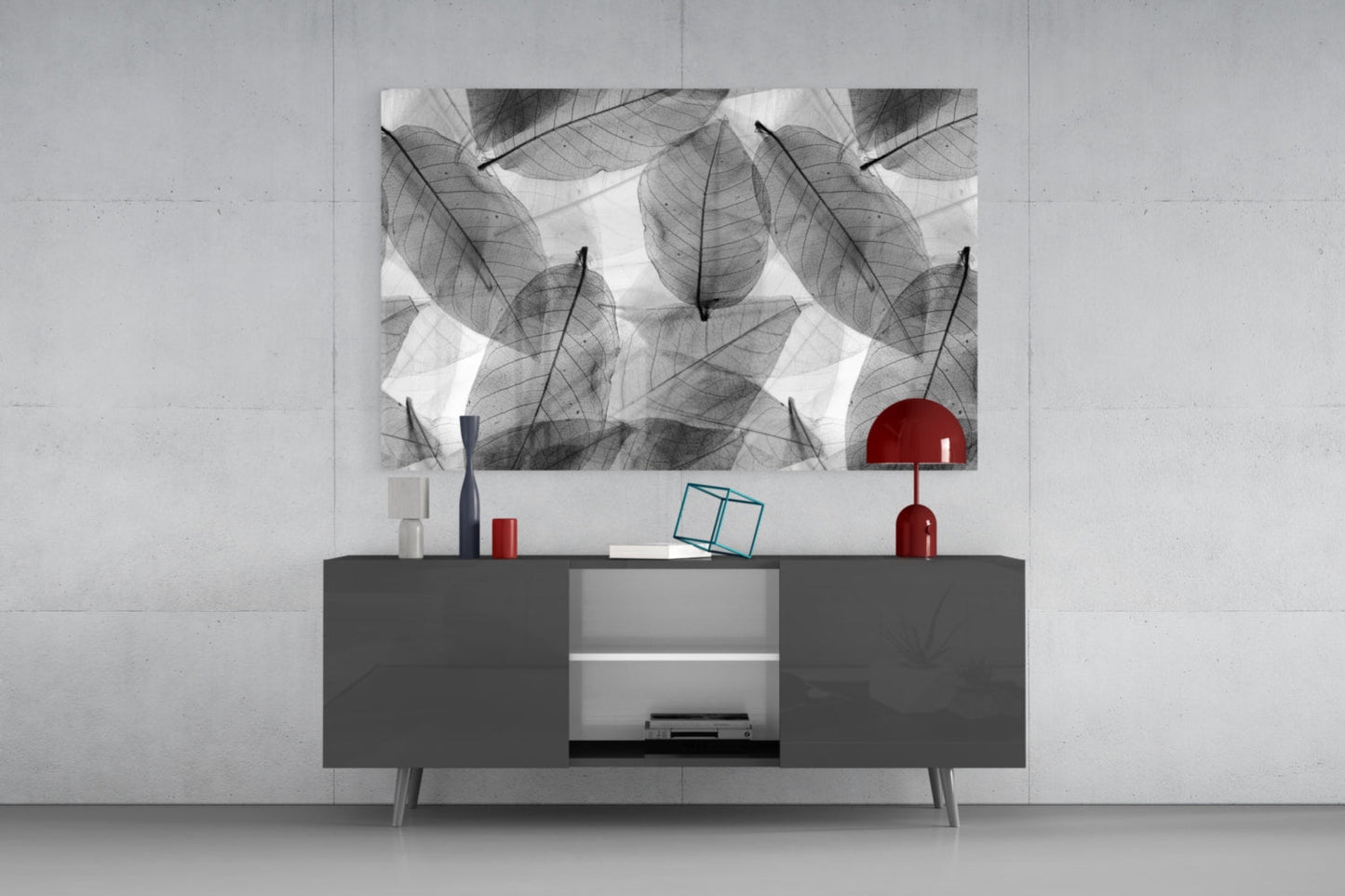 Black and white leaf-patterned glass wall art displayed above a dark gray media console with red decorative accents.