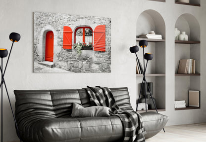 Red Door glass wall art displayed above black leather sofa in modern living room with white arched shelving.
