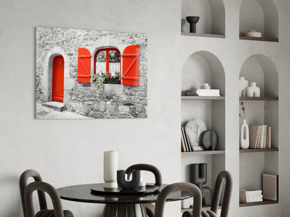 Red door glass wall art displayed above a round black dining table with upholstered chairs in a modern interior with white shelving.