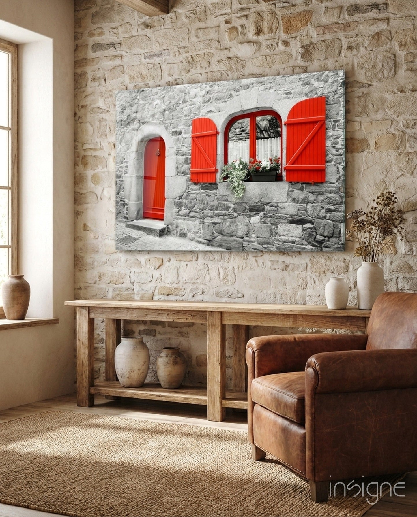 Red Door Glass Wall Art displayed above wooden console table in stone-walled room with leather chair.