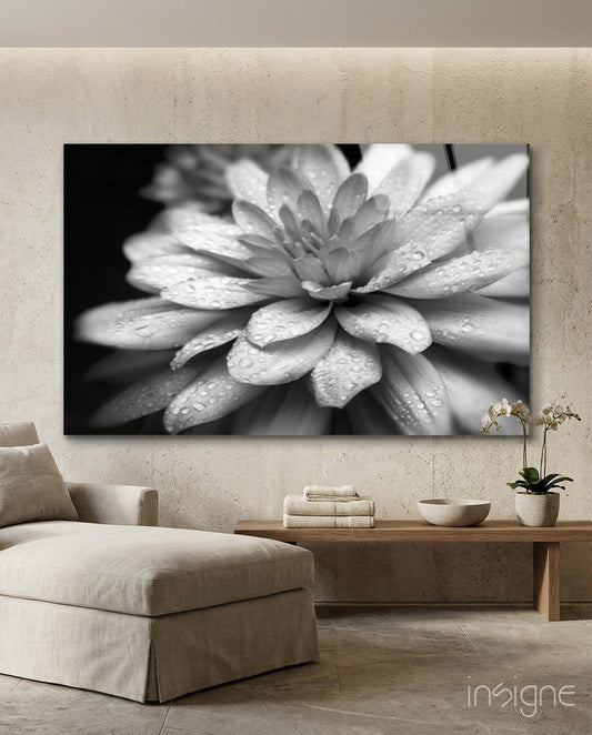 Black and white macro photograph of a dahlia flower with water droplets displayed as wall art in a minimalist beige living room.