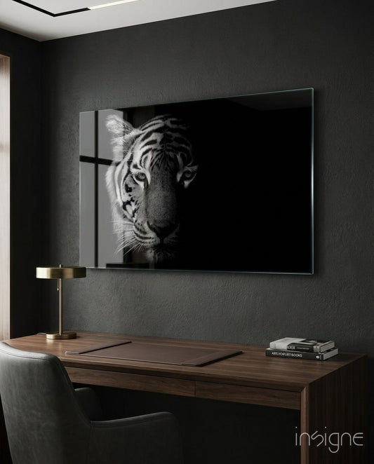 Modern home office with black-and-white tiger glass wall art mounted above wooden desk with brass lamp and books.