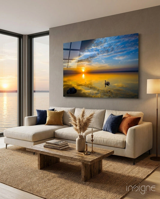 Golden Sunset Lake Swan glass wall art displayed above a cream sectional sofa in a modern waterfront living room.
