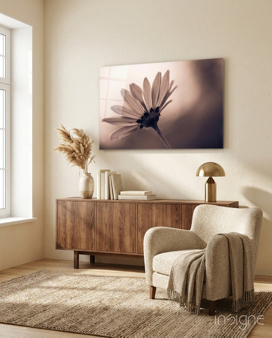 Sepia-toned backlit daisy silhouette canvas displayed above wooden credenza in minimalist beige living room.
