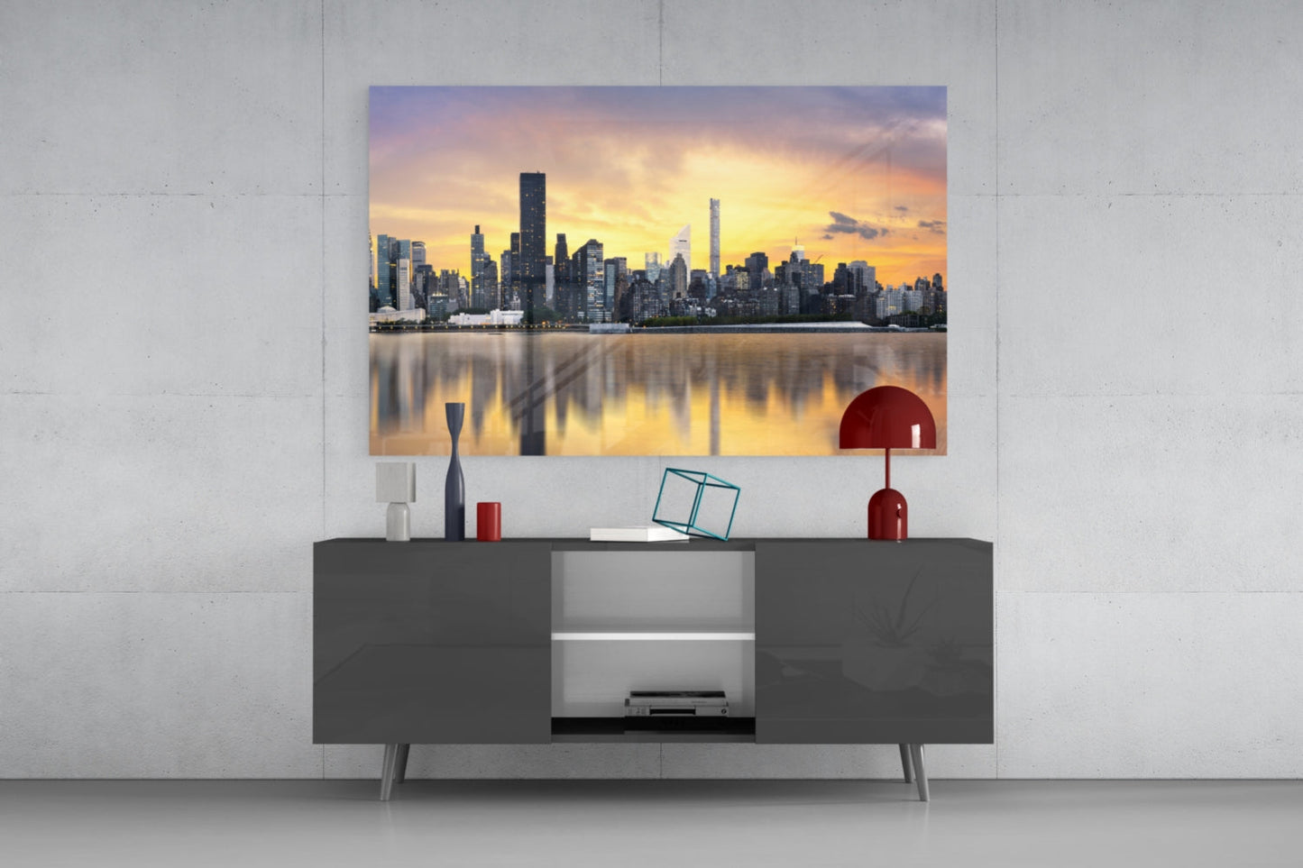 Downtown Glass Wall Art displaying Manhattan skyline at sunset mounted above dark gray media console with red decorative accents.