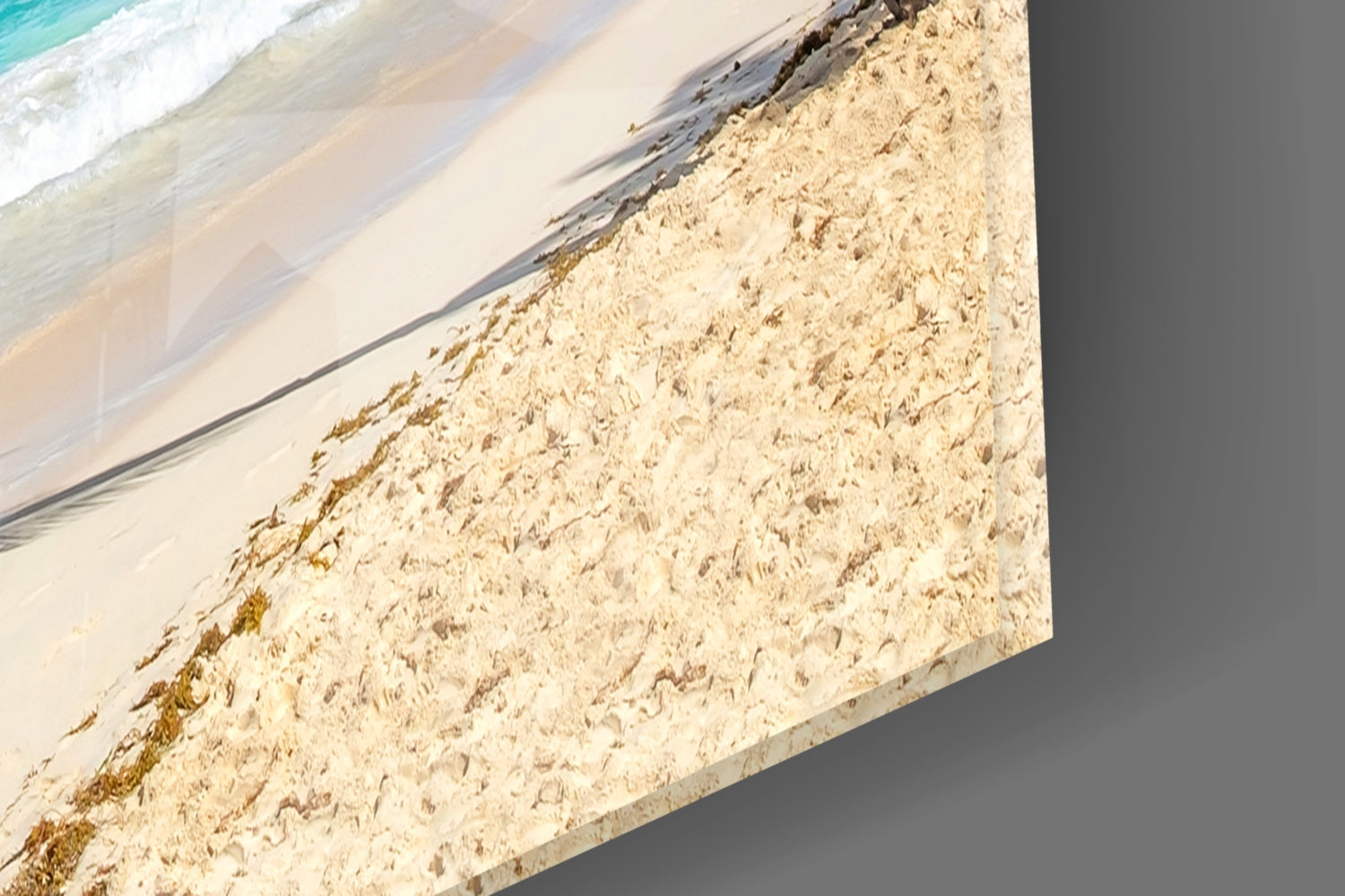 Beach scene with turquoise waves and sandy shoreline printed on glass wall art panel.
