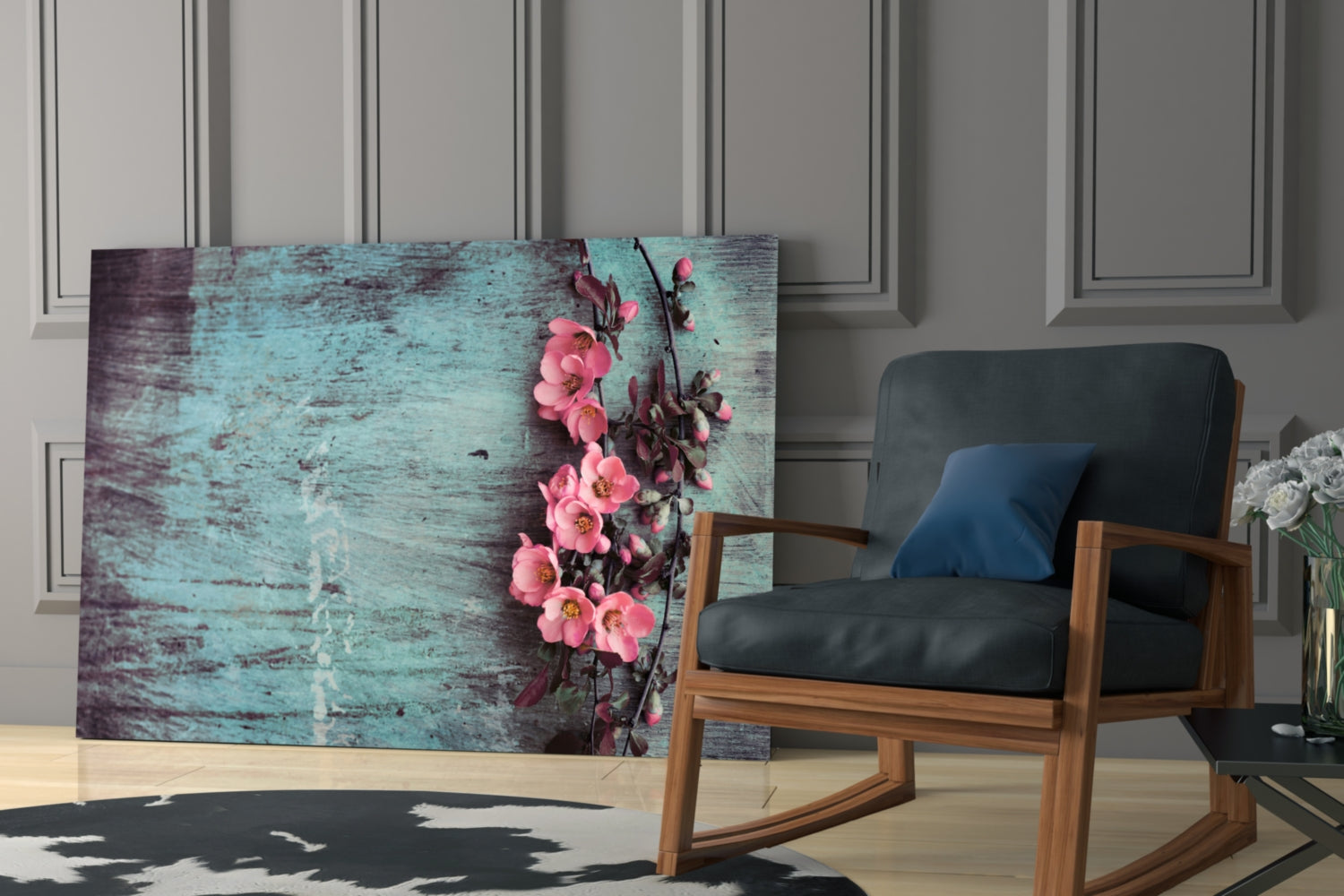 Pastel Flower Glass Wall Art displayed in a modern living room beside a wooden chair, showing pink flowers on distressed turquoise wood background.