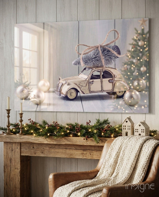 Cream-colored vintage car with evergreen wreath on roof displayed above wooden mantel with holiday garland and decorations.