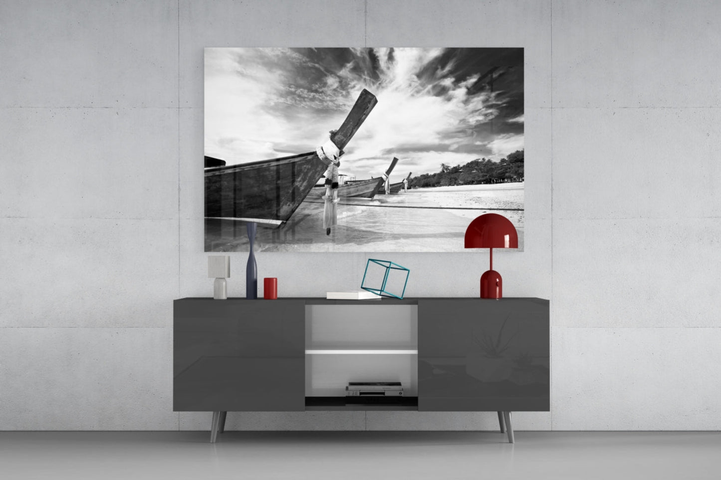Black and white photograph of traditional long-tail boats on water displayed above dark gray media console with red decorative accessories.