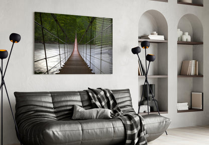 Suspension bridge glass wall art hung above black leather sofa in modern living room with arched shelving.