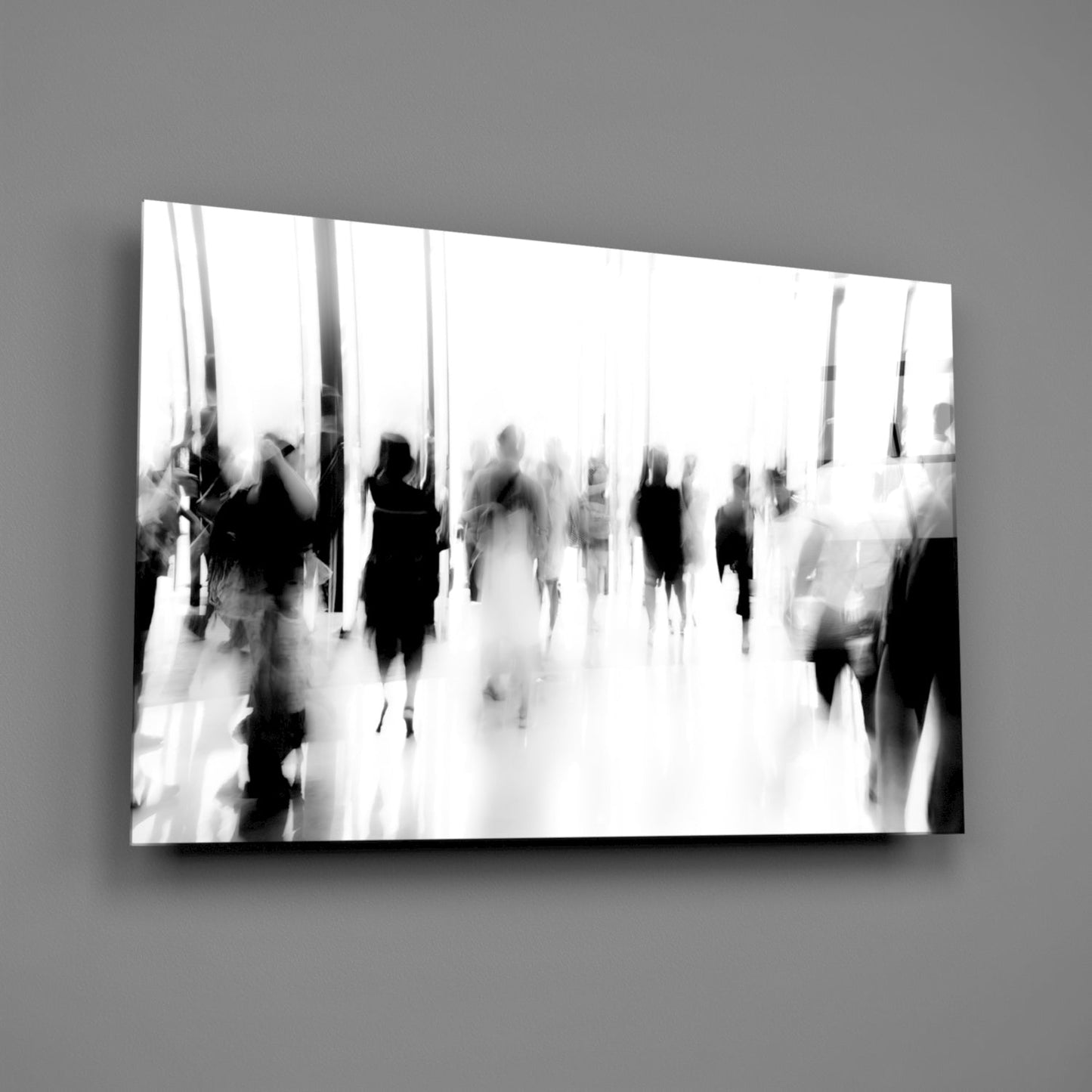 Black and white glass wall art depicting blurred figures moving through a bright, minimalist corridor or public space.