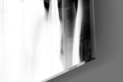 Close-up angled view of translucent white glass panel with blurred crowd silhouettes visible through it, against gray background.