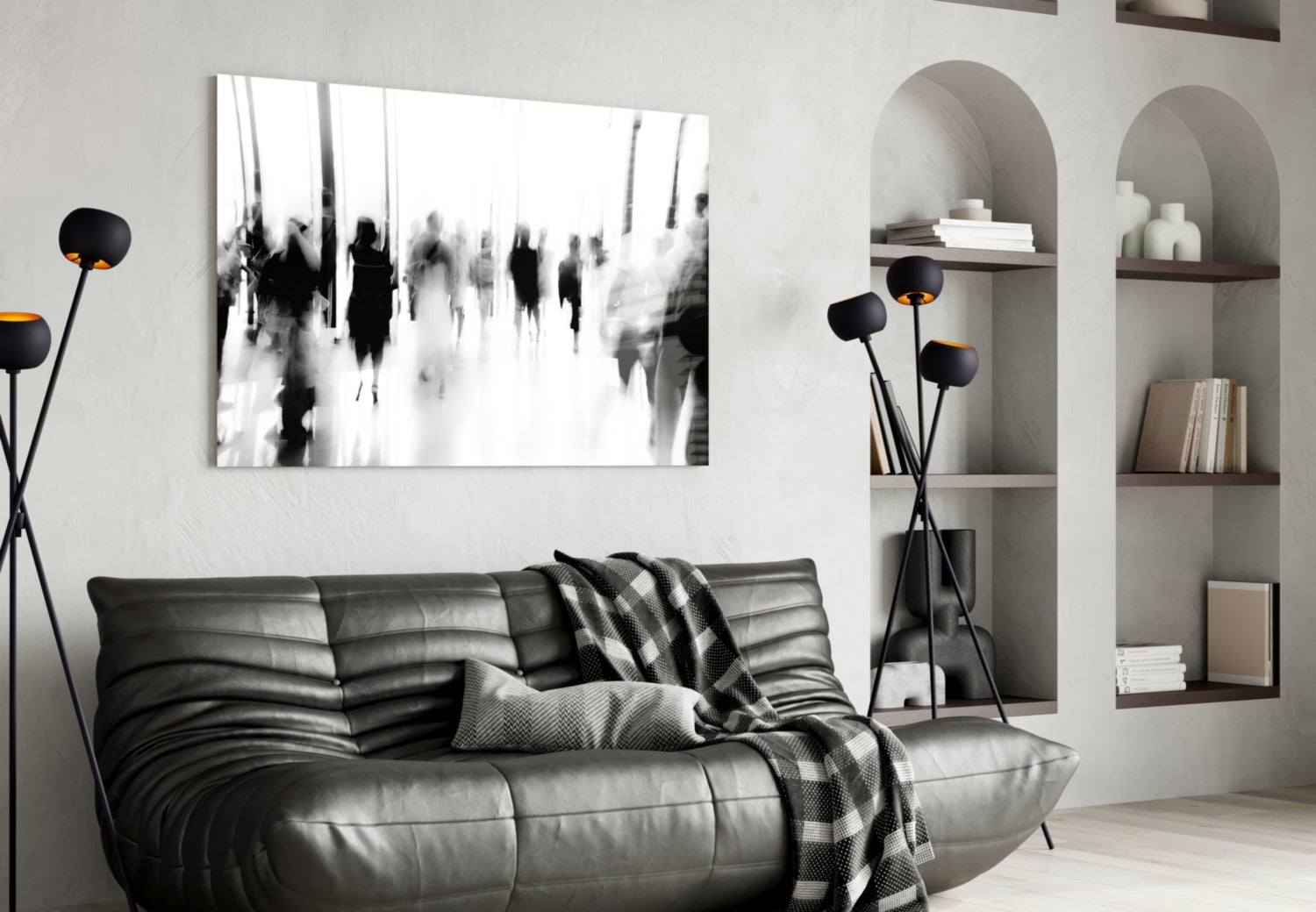 Black and white glass wall art depicting blurred crowd of people displayed above dark leather sofa in modern living room setting.