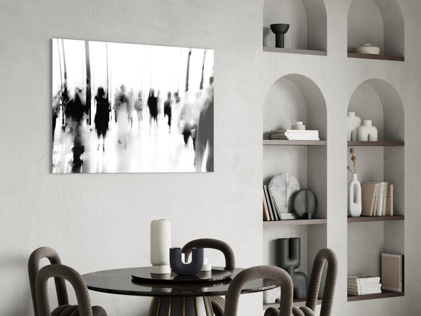 Black and white blurred crowd photograph displayed above round black dining table with upholstered chairs in minimalist interior.