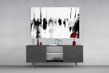 Black and white glass wall art depicting blurred crowds displayed above a dark gray media console with red decorative accents.