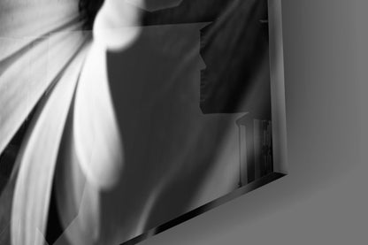 Close-up detail of black and white flower glass wall art showing delicate petals and architectural framing against gray background.