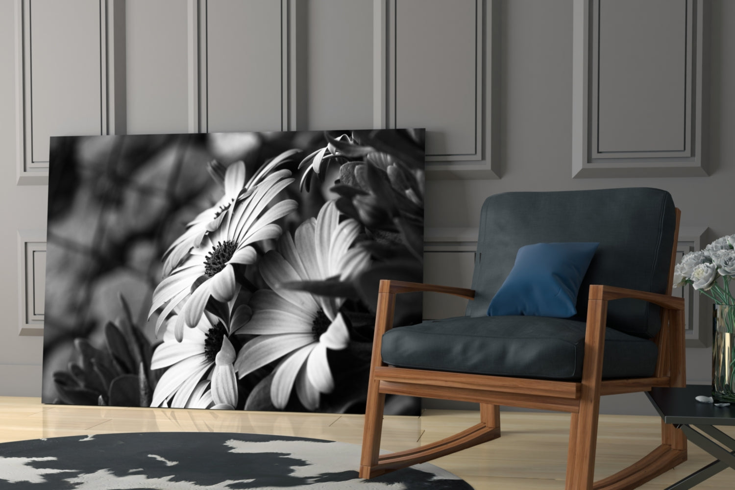 Black and white glass flower artwork displayed on wall behind mid-century wooden chair with dark cushioning in modern interior.