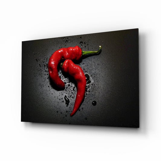 Two red chili peppers with water droplets on dark textured background, displayed as angled glass wall art panel.