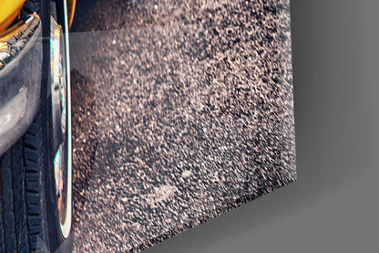 Close-up of yellow taxi door and chrome trim against dark asphalt road surface with shadows.