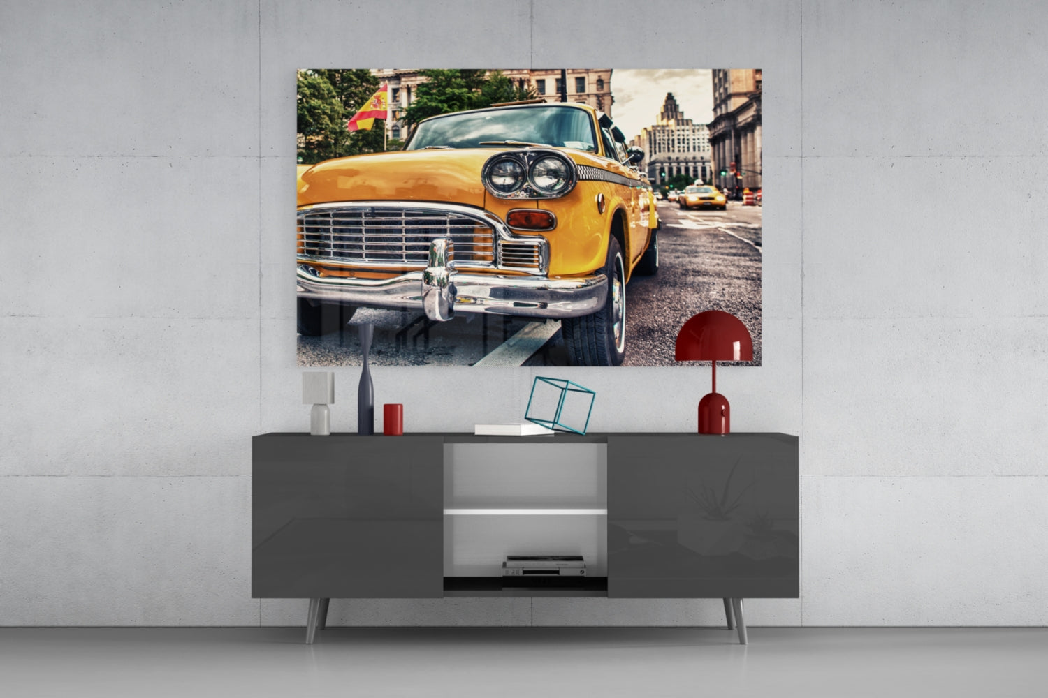 Yellow vintage taxi displayed as glass wall art above a gray media console with decorative items.