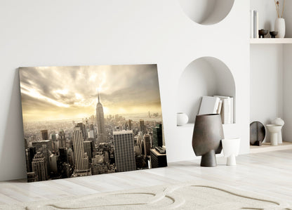 NYC glass wall art leaning against white wall showing sepia-toned Manhattan skyline with Empire State Building.