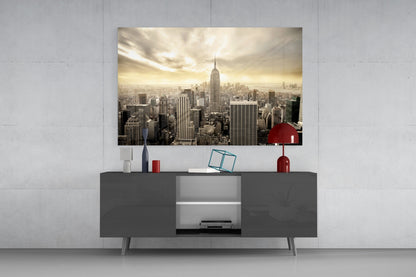 Sepia-toned NYC skyline glass wall art displayed above dark gray media console with red decorative accessories.