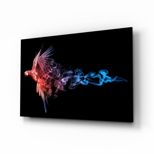 Glass wall art displaying a red parrot dissolving into colorful smoke trails in blue and purple tones against black background.