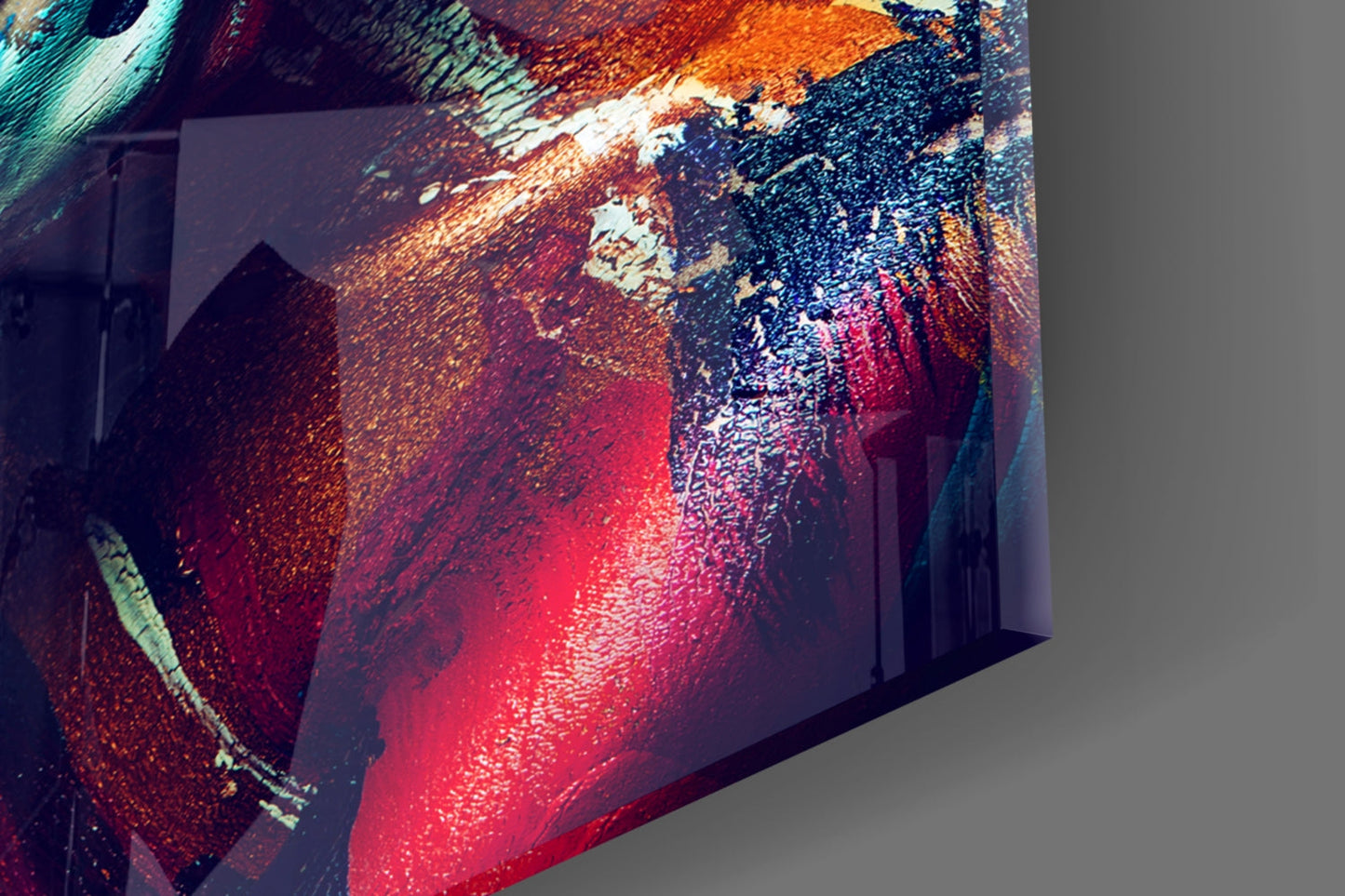 Angled perspective view of illuminated glass wall art displaying abstract female portrait in vibrant red, orange, teal, and dark blue tones.
