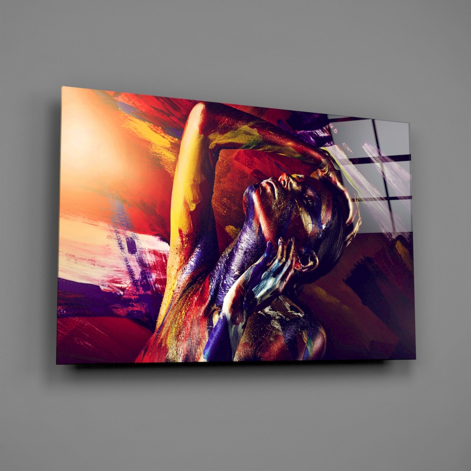 Modern glass wall art displaying an abstract woman's portrait in vibrant reds, golds, and purples with dynamic brushstroke effects.
