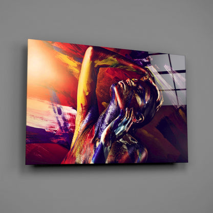Modern glass wall art displaying an abstract woman's portrait in vibrant reds, golds, and purples with dynamic brushstroke effects.