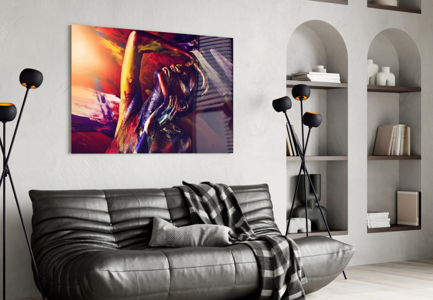 Colorful abstract glass wall art featuring warm red, orange, and purple tones displayed above a black leather sofa in a modern living room.