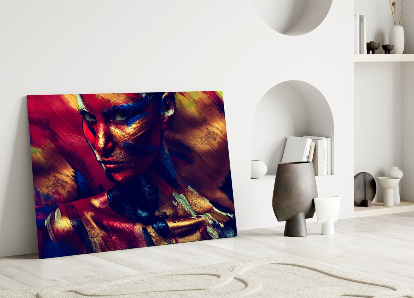 Vibrant glass wall art depicting a colorful female portrait with red, gold, and blue tones leaning against white interior wall.