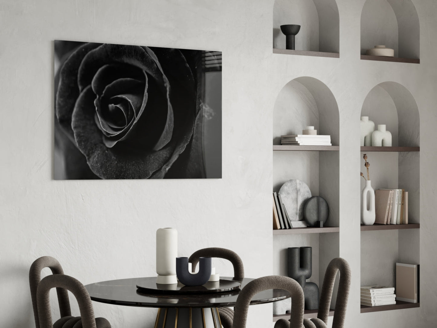 Black rose glass wall art displayed above a round black dining table with upholstered chairs and styled shelving.