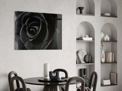 Black rose glass wall art displayed above a round black dining table with upholstered chairs and styled shelving.