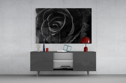 Black and white rose photograph displayed on wall above gray media console with red decorative accessories.