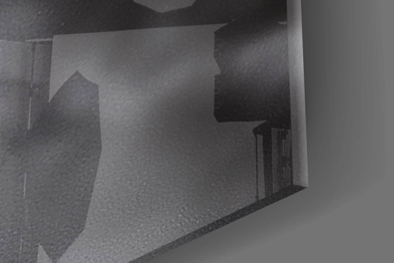 Close-up angled view of frosted glass wall art showing woman's profile silhouette in grayscale tones.
