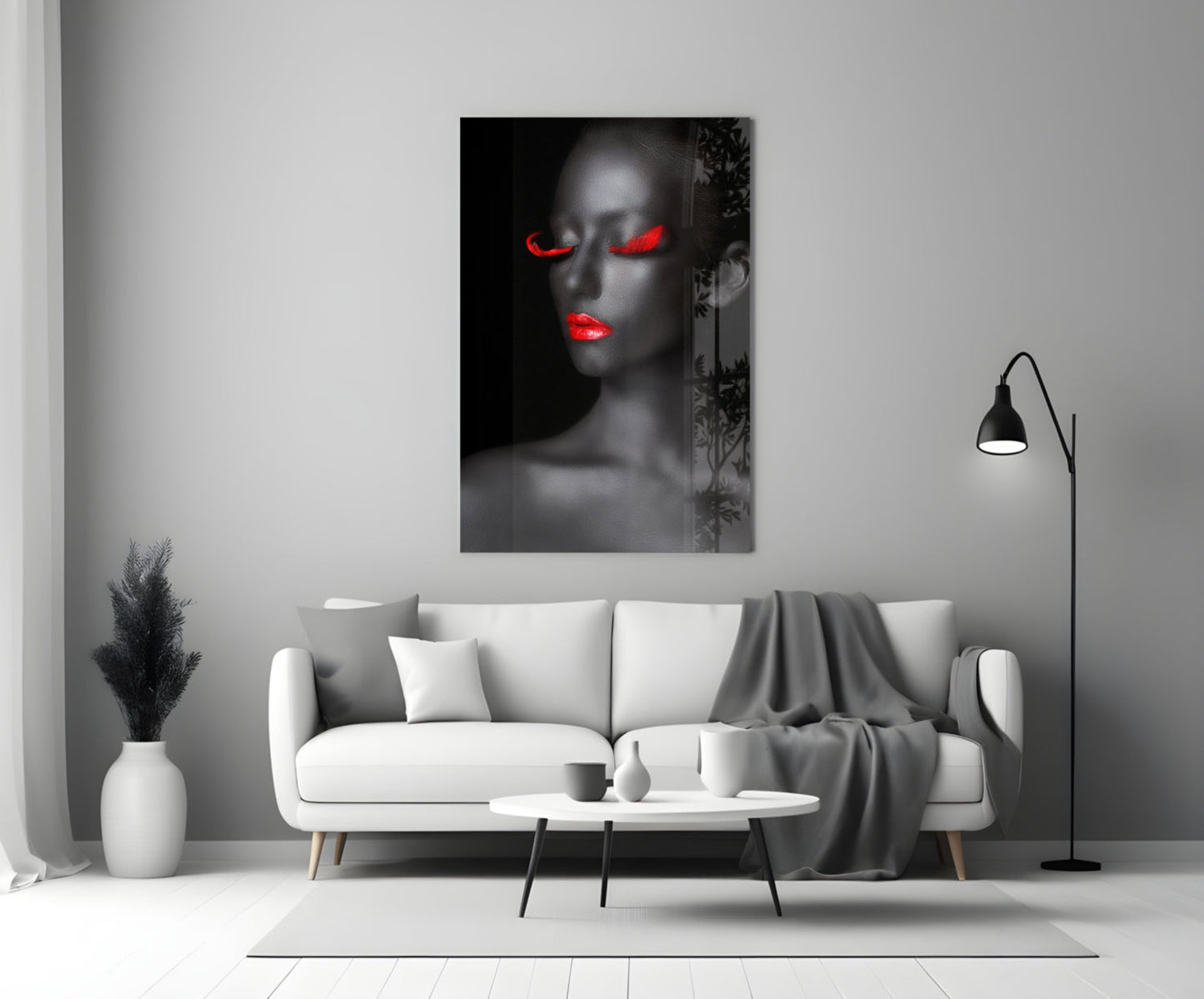 Woman portrait glass wall art with grayscale face and glowing red eyes and lips, displayed above white sofa in modern living room.