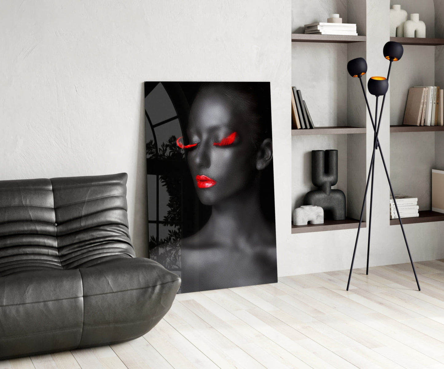 Modern living room featuring black and red portrait glass art leaning against white wall beside gray leather chair.