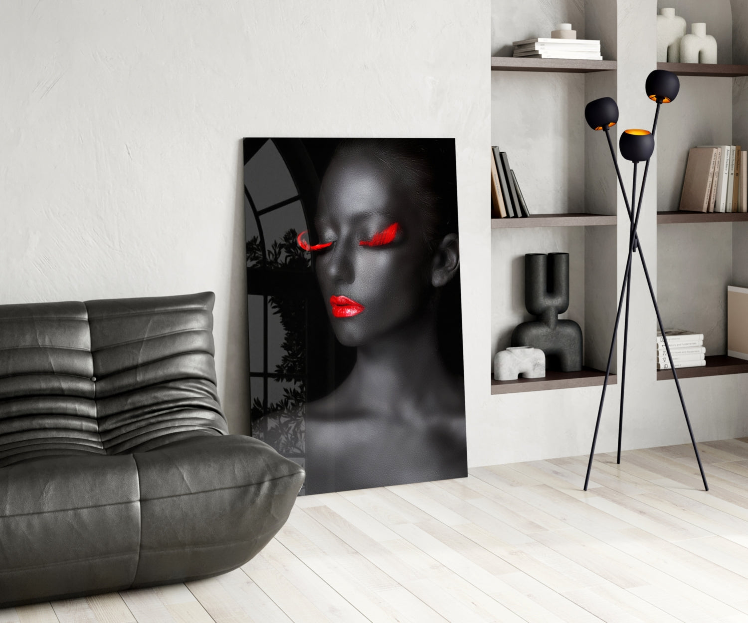 Modern living room featuring black and red portrait glass art leaning against white wall beside gray leather chair.