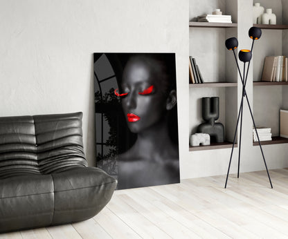 Modern living room featuring black and red portrait glass art leaning against white wall beside gray leather chair.
