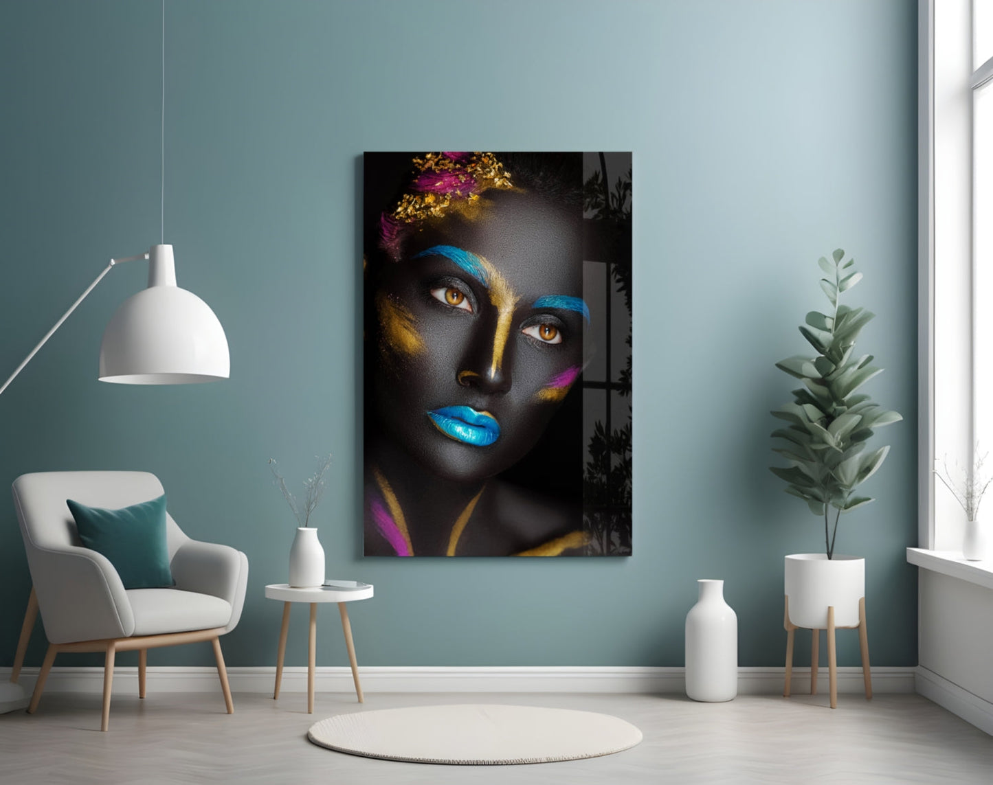 Glass wall art portrait of a woman with black skin, golden and blue face paint, colorful flowers, and vibrant blue lips displayed in a modern living room setting.