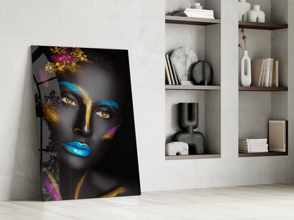 Glass portrait artwork leaning against white wall beside built-in shelving displaying decorative objects and books.