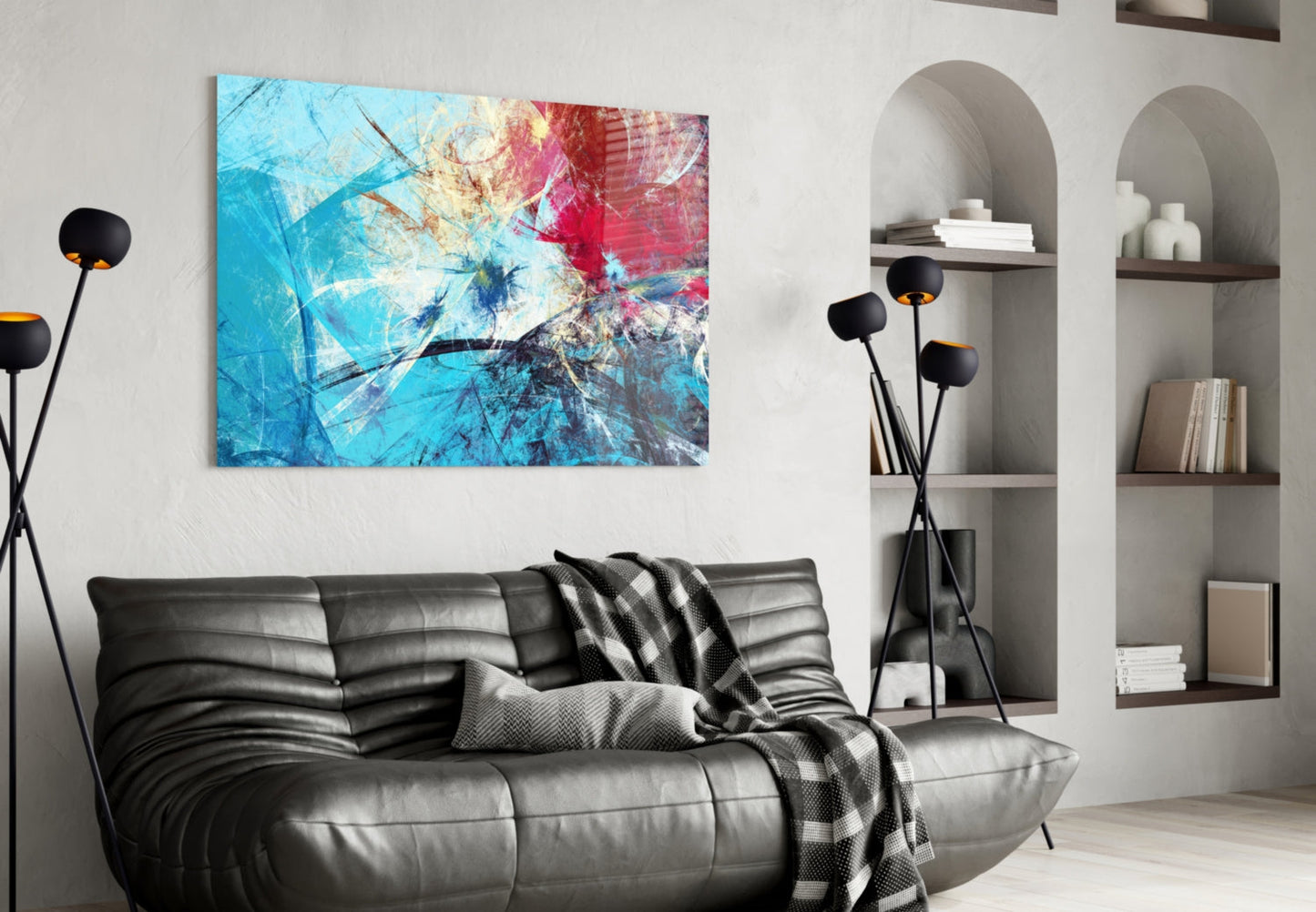Colorful abstract glass wall art with blue, red, and yellow swirls displayed above a black leather sofa in a modern living room.