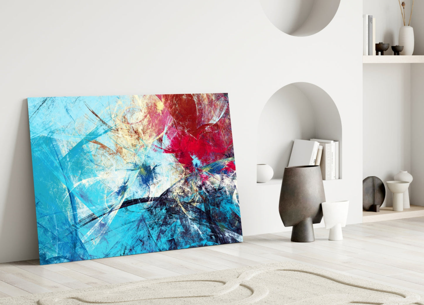 Colorful abstract glass wall art with blue, red, and yellow streaks displayed in minimalist white interior space with decorative objects.