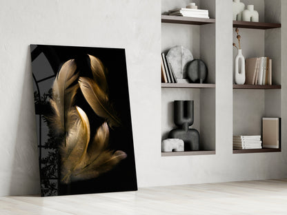 Tan feather glass wall art leaning against white wall beside built-in shelving with decorative objects and books.